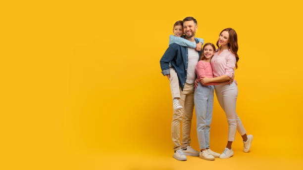 istock Family embraced and smiling on yellow background 2157066247