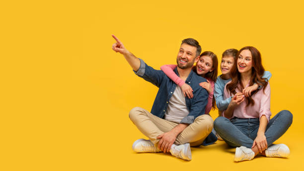 Happy family sitting together and pointing up