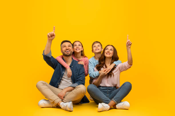 istock Look There. Parents With Two Kids Sitting On Floor And Pointing Up 2157066458