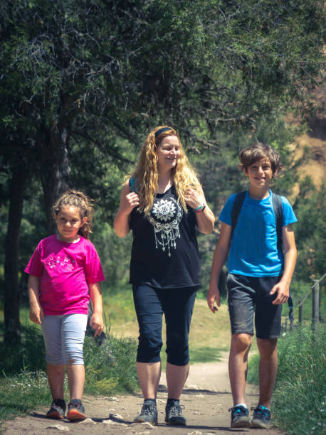 istock Mother walking with her young son and daughter on a dirt path 2157067382
