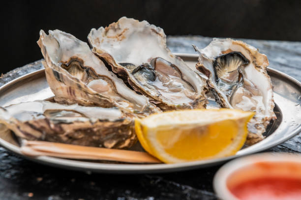 istock several oysters, with a slice of lemon on a silver plate 2157068687