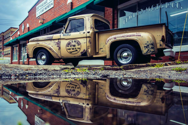 Greeneville, United States – June 09, 2020: A vintage truck parked by store, reflected in puddle