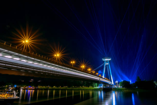 istock Lights and traffic on a bridge illuminate the night 2157071462
