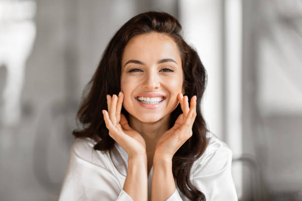 istock Smiling beautiful woman touching her face gently 2157072993