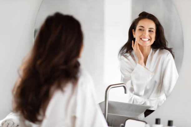 istock Smiling woman admiring herself in bathroom mirror 2157073054