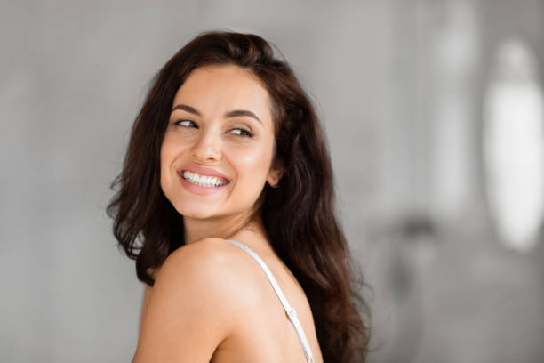 istock Smiling woman looking back over shoulder, copy space 2157073128