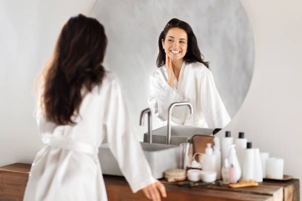 istock Attractive brunette long-haired millennial woman looking at mirror 2157073147