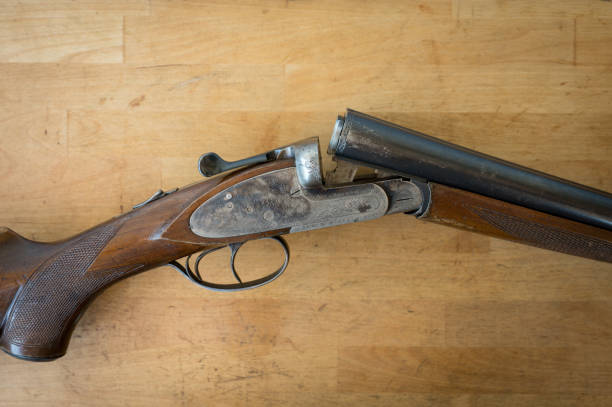 istock nice old open 12 gauge parallel shotgun on a wooden table 2157073214