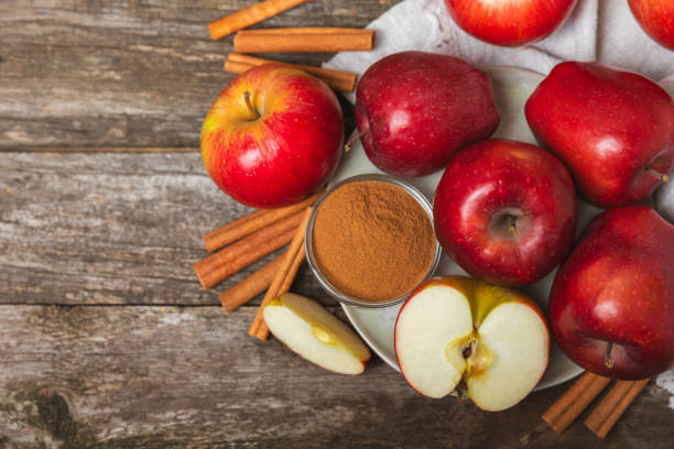 istock Apples with cinnamon on a textured wooden background. Fragrant red spiced apples with cinnamon sticks and star anise. Apple slices with spicy spices. Place for text. Copy space. Harvesting. Fruits. 2157074380