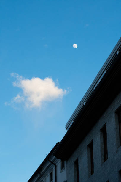 istock the moon is setting and a few clouds are visible in the sky 2157074672
