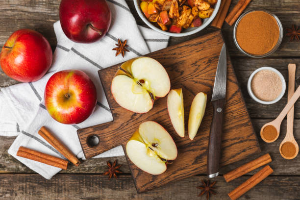 istock Apples with cinnamon on a textured wooden background. Fragrant red spiced apples with cinnamon sticks and star anise. Apple slices with spicy spices. Place for text. Copy space. Harvesting. Fruits. 2157074796