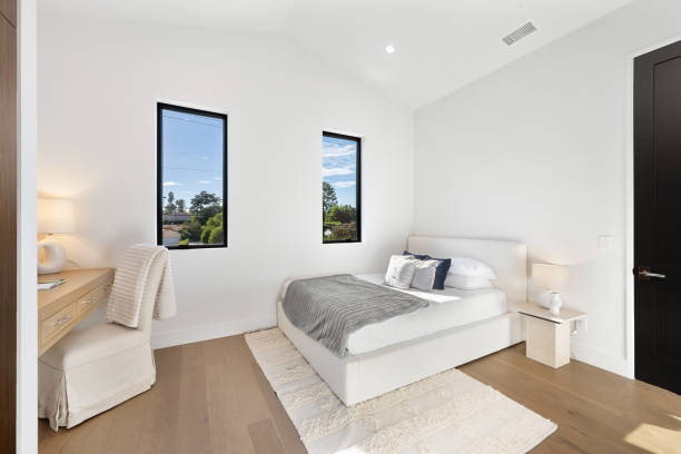 istock Modern bedroom with a bed and desk positioned by a window 2157075120