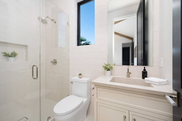 istock Bathroom with a toilet, wall mirror, and a glass shower 2157075126
