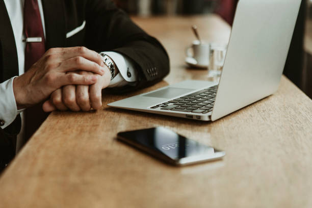 Businessman looking at his watch in a cafe