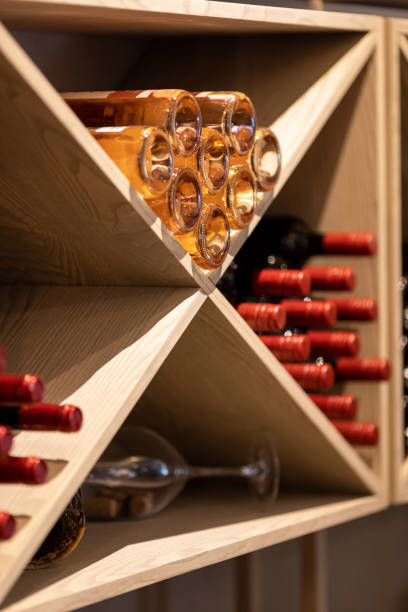 istock Light wood wine rack with bottles, white, pink, orange, red wine 2157075950
