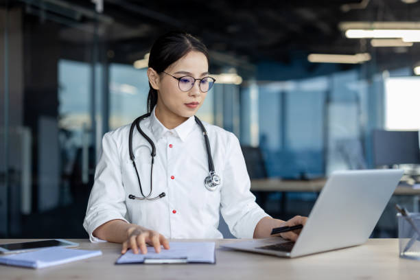 istock Serious Asian doctor thinking while working on a laptop 2157077003