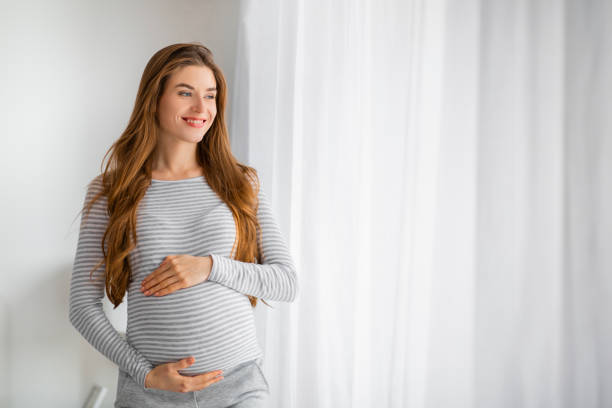 istock Pregnant woman looking out the window 2157077894