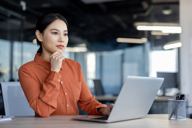 istock Focused businesswoman working on laptop in modern office setting 2157077974