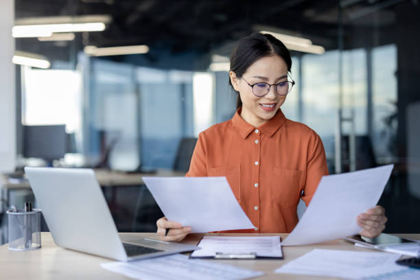 istock Businesswoman reviewing documents in modern office setting 2157078077