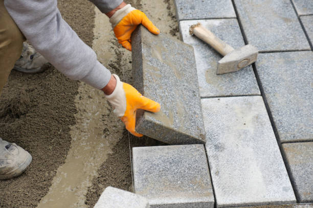 istock a worker laying concrete bricks on each other for building a new sidewalk 2157078605