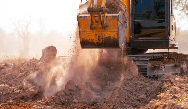 istock Close-up of excavator at construction site. Backhoe digging soil for earthwork and construction business. Excavating machine at work. Heavy machinery for earth moving and construction site development 2157080010
