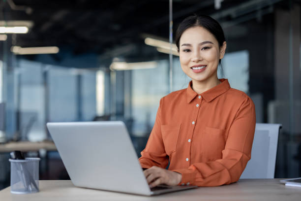 istock Happy businesswoman working on laptop in modern office environment 2157080251