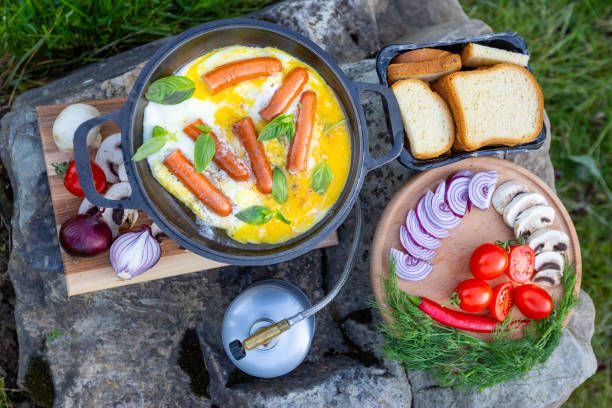 Cooking food in a frying pan, near a fire in the open air.