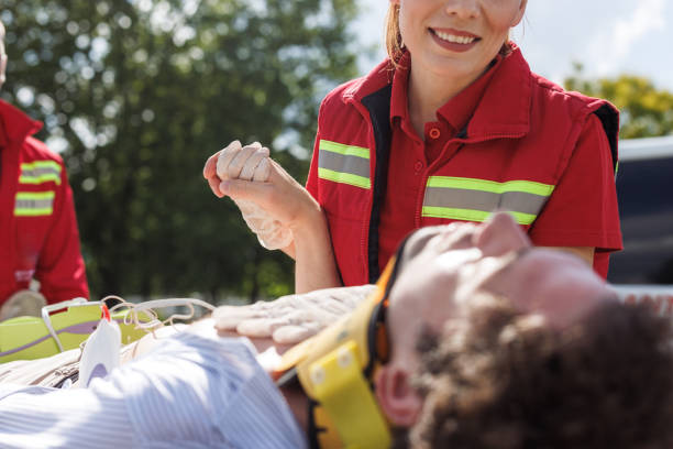 Emergency medical team providing care to an injured man. Paramedics offering first aid and assistance during a rescue operation outdoors.