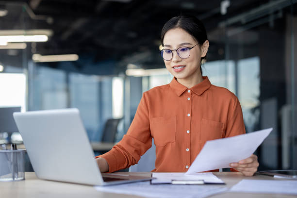 istock Young professional woman working on laptop in modern office environment 2157081706