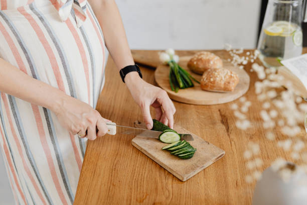 istock Expecting mother cutting zucchini in the kitchen 2157082338