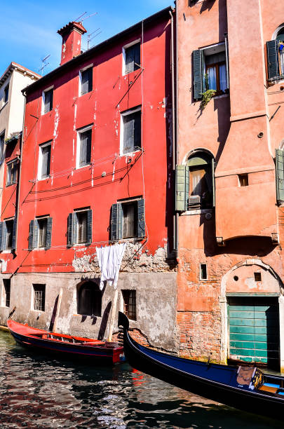 istock A red building with a balcony and a blue boat in front of it 2157082756