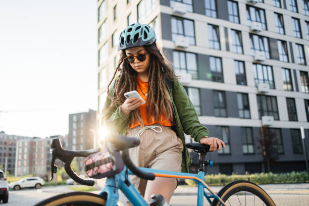istock Stylish Young Woman Cyclist Using Smartphone in Urban Setting 2157083638