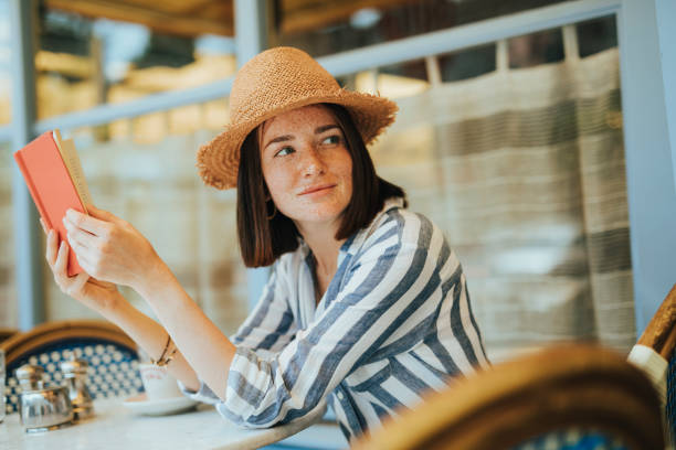 istock Woman reading a book at a cafe 2157084788