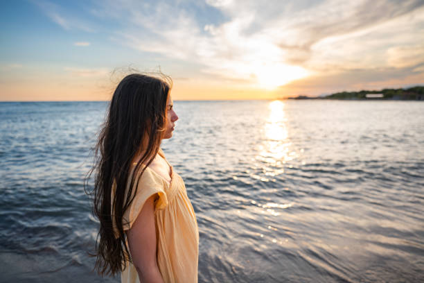 istock Woman at the beach during sunset 2157086205