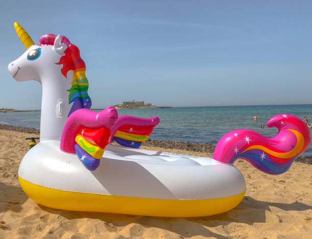 istock Funny inflatable unicorn ring on sandy beach near sea. 2157088094