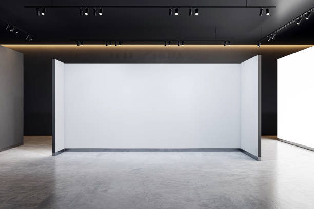 istock An empty exhibition room with a large blank presswall, modern design, and a concrete floor, in a dark setting, ideal for branding displays. 3D Rendering 2157088334