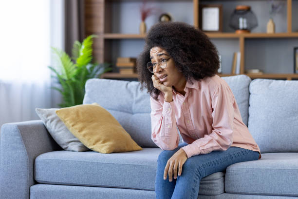 istock Woman feeling stressed and anxious while sitting on a couch at home 2157090587