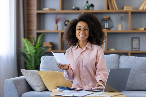 istock Happy woman doing finances at home while working on a laptop 2157093317