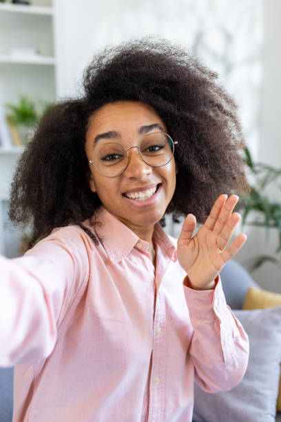 istock Cheerful person waving and smiling during a video call 2157093795