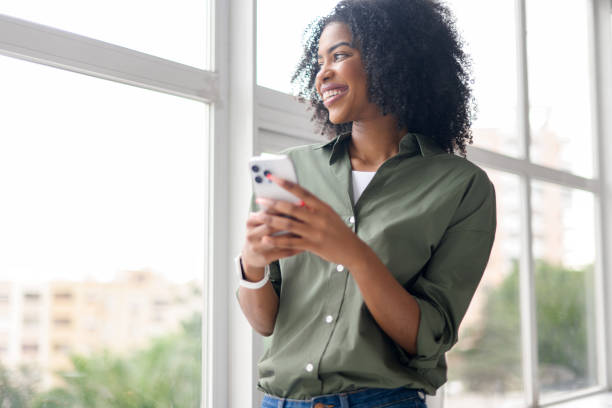 istock An African-American woman holds her smartphone with a joyful expression 2157102879