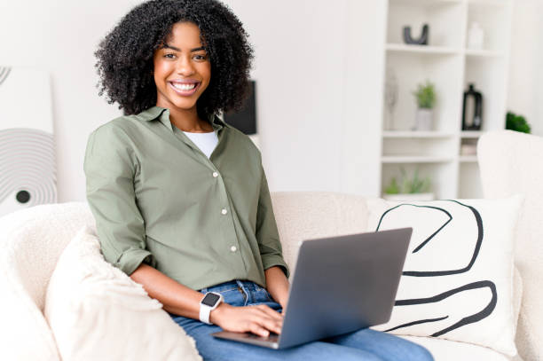 istock A cheerful African-American woman interacts with her laptop 2157102896