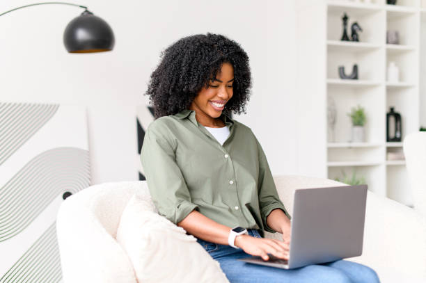 istock A cheerful African-American woman interacts with her laptop 2157102904