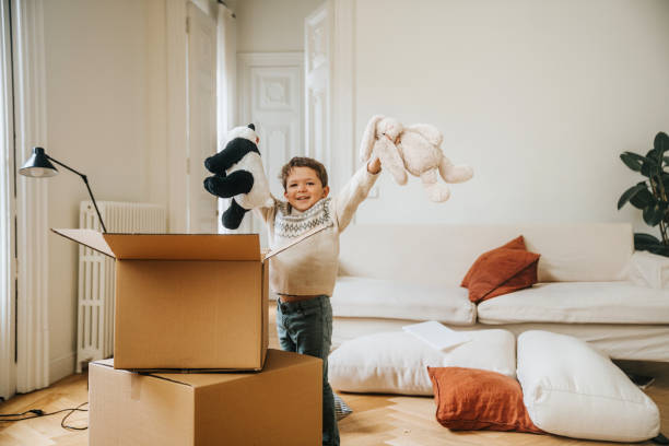 istock Little boy opening boxes in his new house 2157104205