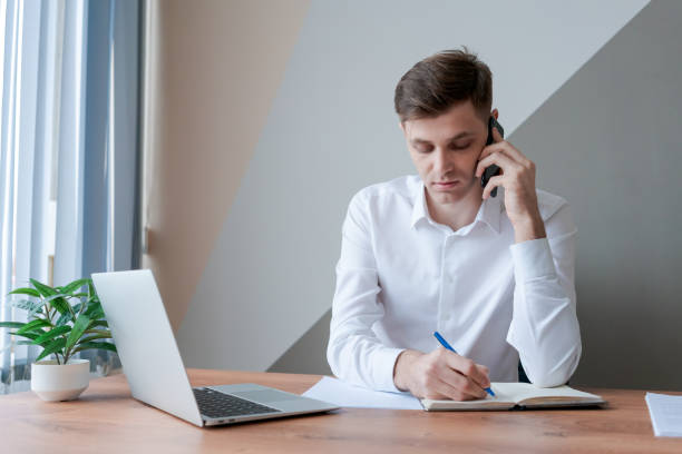 istock A man is sitting at a desk with a laptop and a notebook 2157107039