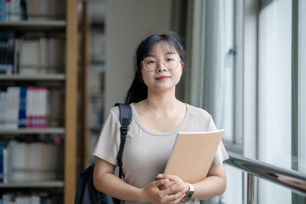 istock asian female student in library 2157108078