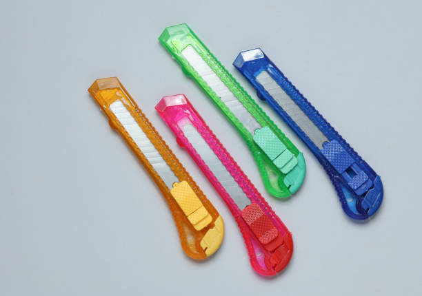 istock Plastic colored stationery knives for cutting paper on a gray background 2157109377