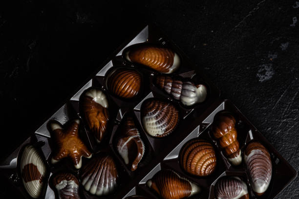 istock Chocolate candies in the shape of shells on a dark background 2157112779