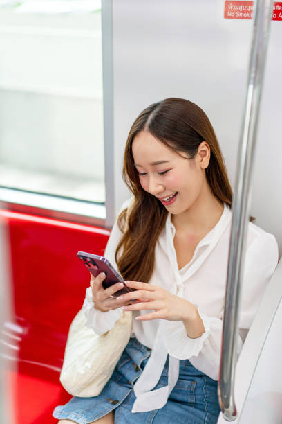 istock Asian woman sitting and using phone while commuting on a metro skytrain 2157113486