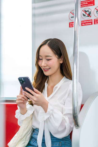 istock Asian woman sitting and using phone while commuting on a metro skytrain 2157113517