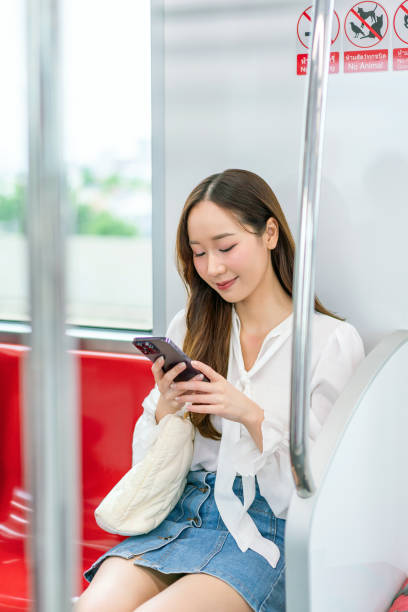istock Asian woman sitting and using phone while commuting on a metro skytrain 2157113562
